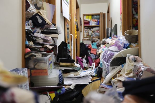 Image shows a house hallway overflowing with items.