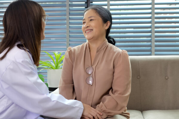 Smiling young female doctor enjoying conversation with happy senior woman